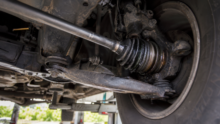 Cardan avant de 4x4 avec soufflet endommagé sous le véhicule