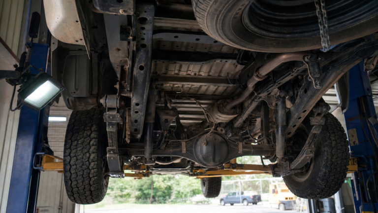 Dessous de châssis de pick-up inspecté sur un pont élévateur